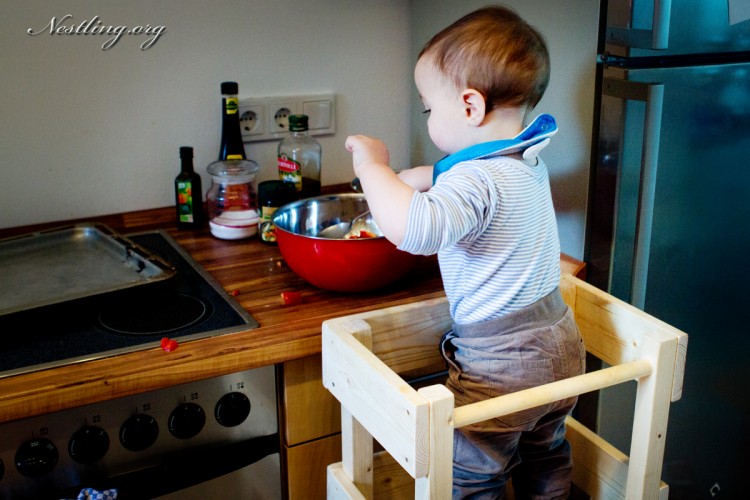 Der Bub beim Kochen auf dem Lernturm. lernturm